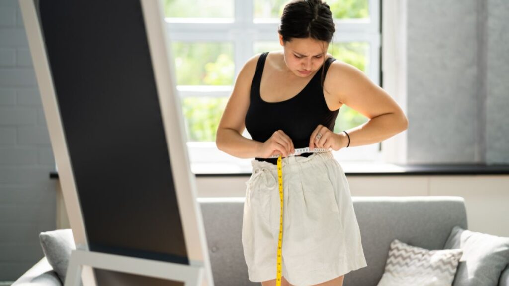 Woman Measuring Her Waist With A Measuring Tape