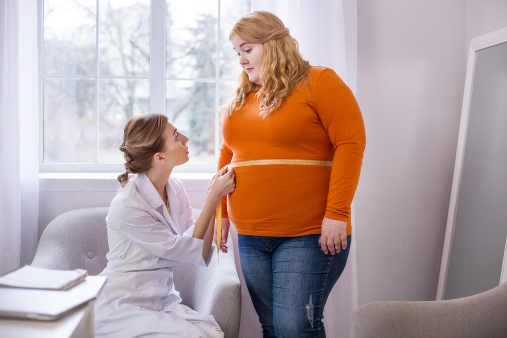 healthcare-professional-measuring-a-womans-stomach